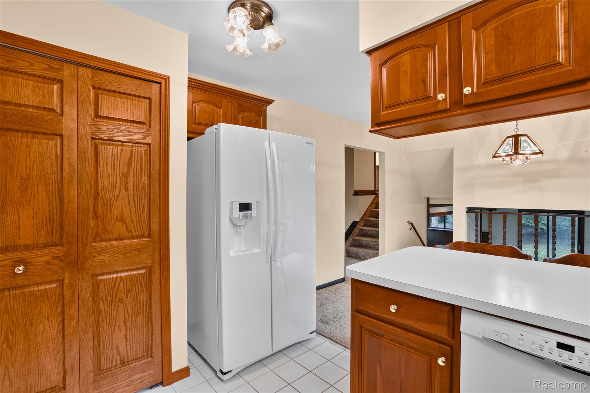 16955 English Road Manchester, MI 48158 - Photo 12 of 37 Kitchen area featuring wood cabinetry, white countertops, and integrated white appliances