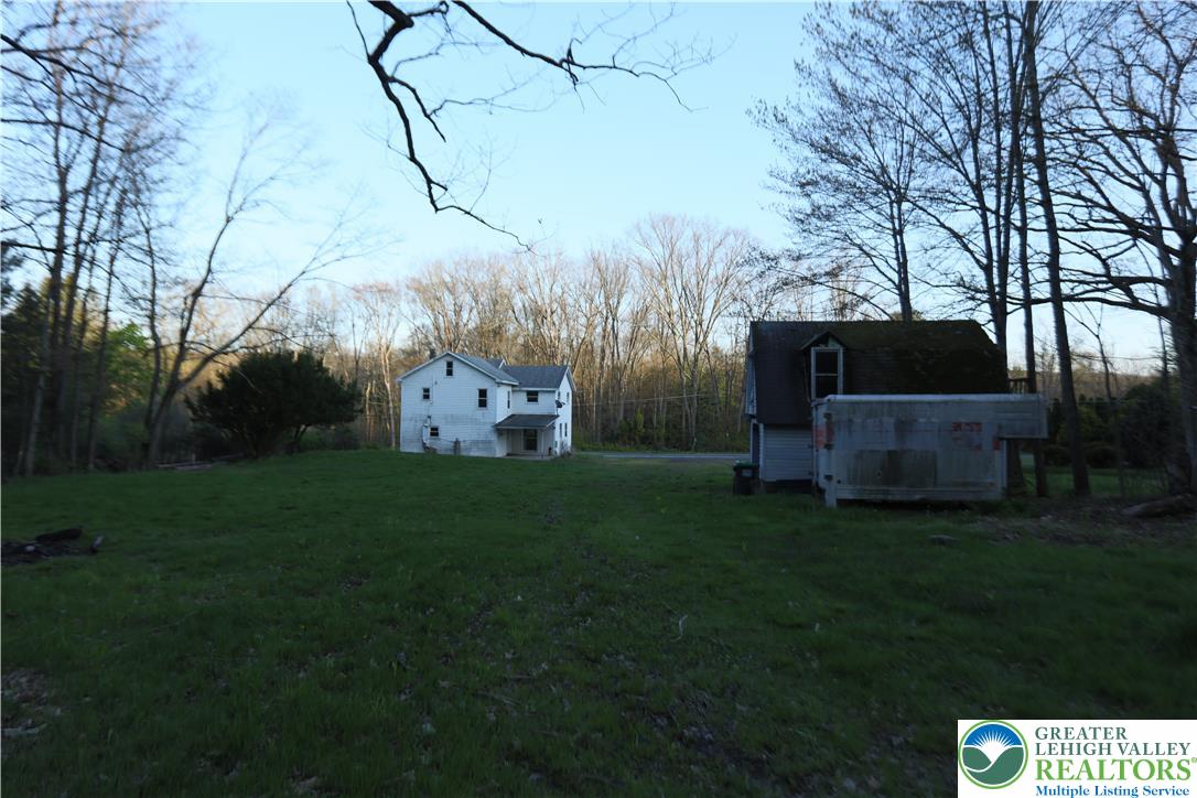 5444 Quakake Road Weatherly, PA 18255 - Photo 9 of 21 A rural setting featuring two residential structures amidst a wooded landscape.