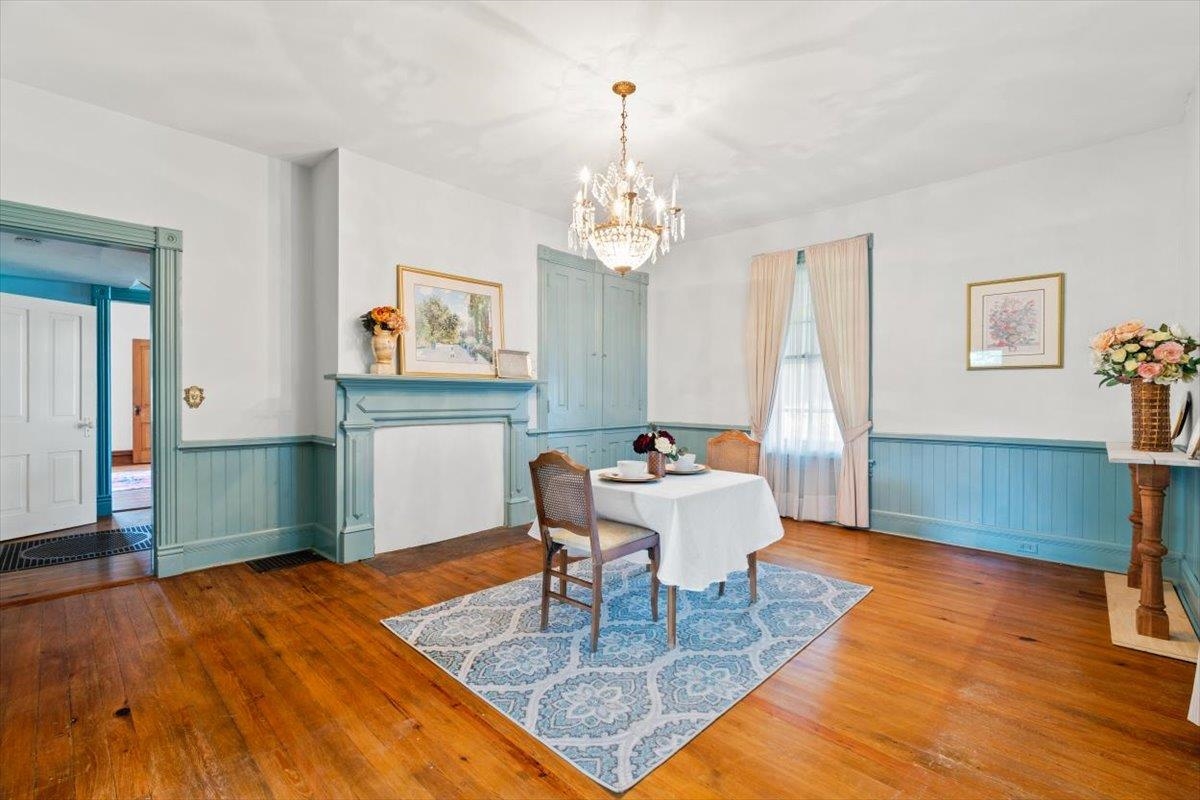 1188 Patterson Mill Road Grottoes, VA 24441 - Photo 17 of 58 a dining room with wooden floor a chandelier a wooden table and chairs