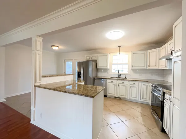 a kitchen with stainless steel appliances granite countertop a sink stove and cabinets