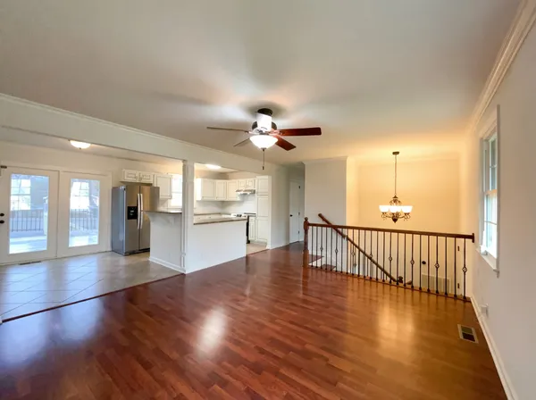 a view of a livingroom with wooden floor and a ceiling fan