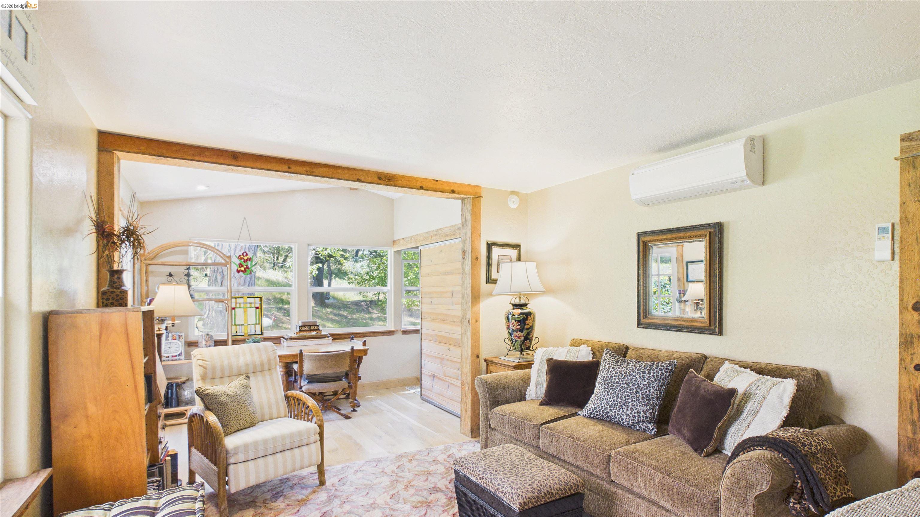 18102 Mt Eaton Road Tuolumne, CA 95379 - Photo 21 of 44 Living area featuring wood-finish flooring, a wood-trimmed opening, and an exposed wood beam