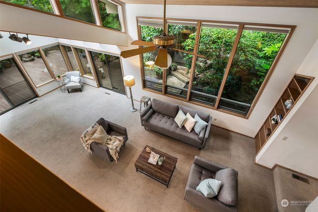 a living room with furniture a fireplace and a large window