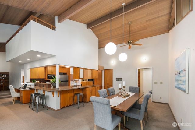 a kitchen with stainless steel appliances granite countertop a table chairs and a refrigerator