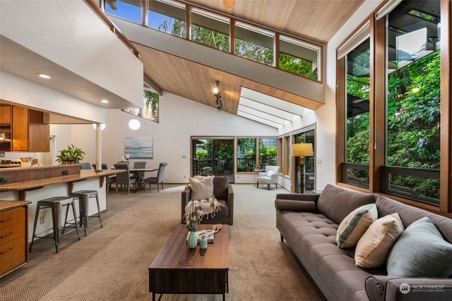 a living room with fireplace furniture and a large window
