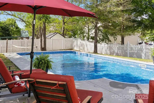 a backyard of a house with table and chairs under an umbrella