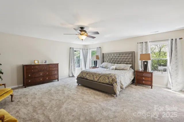 a spacious bedroom with a bed and a ceiling fan