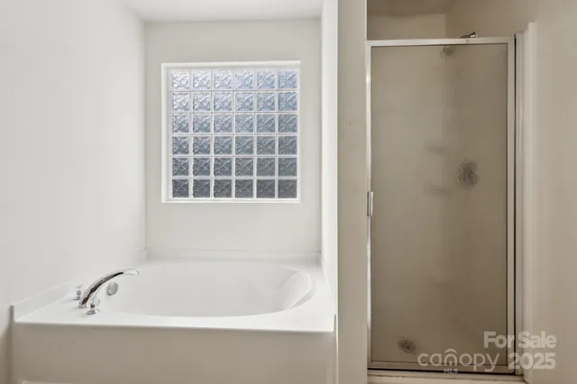 a white bath tub sitting next to a shower