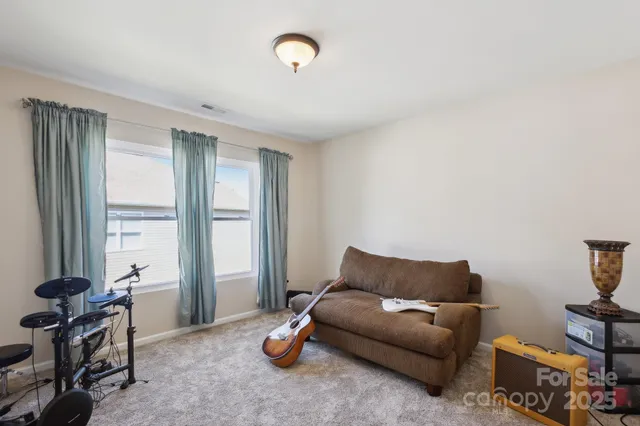 a living room with furniture a window and a flat screen tv