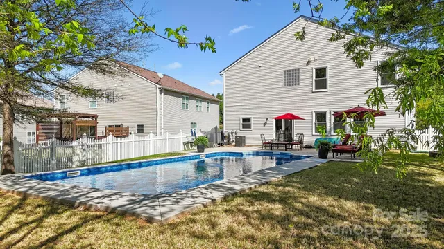 a view of a house with swimming pool and sitting area