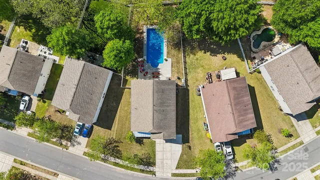 an aerial view of a residential apartment building with a yard and large tree