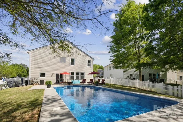a view of a house with pool and sitting area