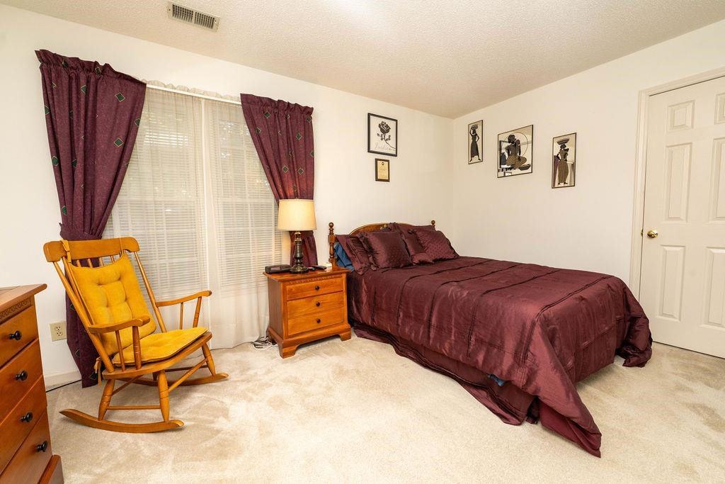 119 Nuttree Way Durham, NC 27713 - Photo 29 of 41 a spacious bedroom with a bed and chair