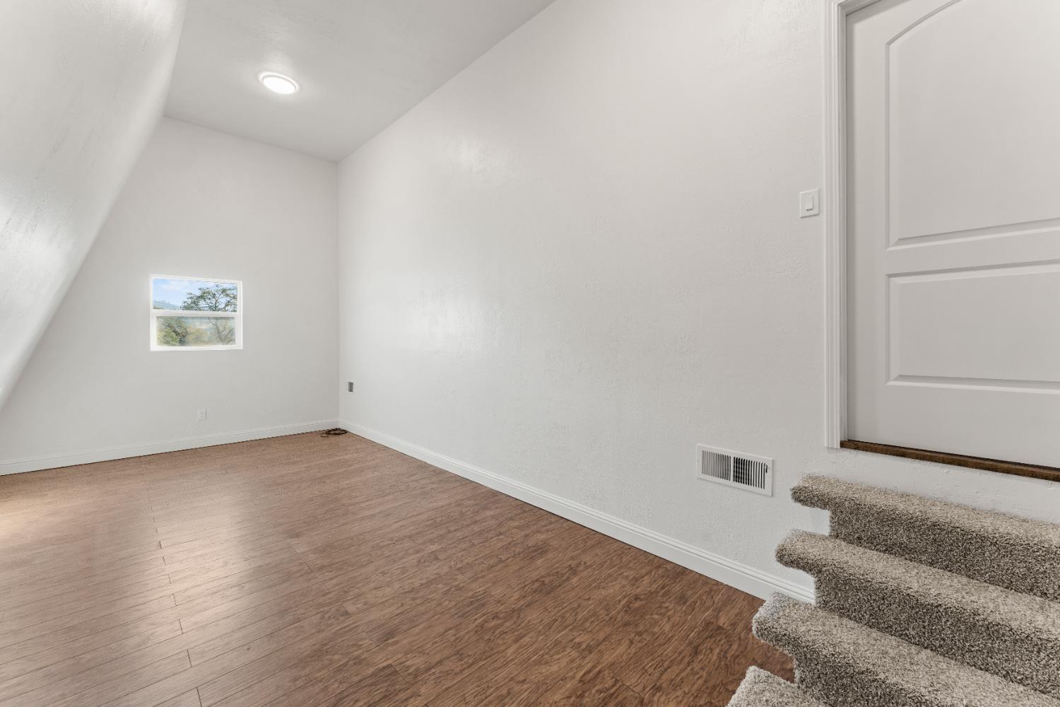 5585 Garden Bar Road, Unit 2 Lincoln, CA 95648 - Photo 19 of 65 a view of an empty room with wooden floor and a window