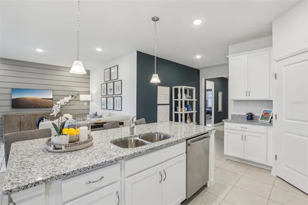 a kitchen with stainless steel appliances granite countertop a sink refrigerator and cabinets