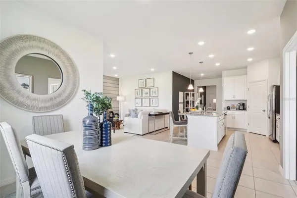 a living room with furniture a potted plant and kitchen view