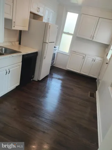 a kitchen with cabinets and wooden floor