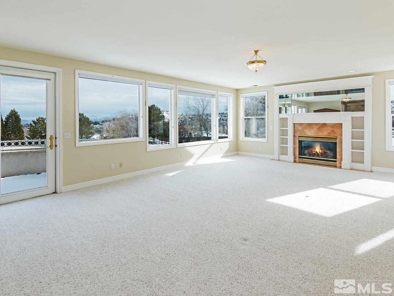 4195 Basque Lane Reno, NV 89519 - Photo 13 of 24 an empty room with windows fireplace and natural light