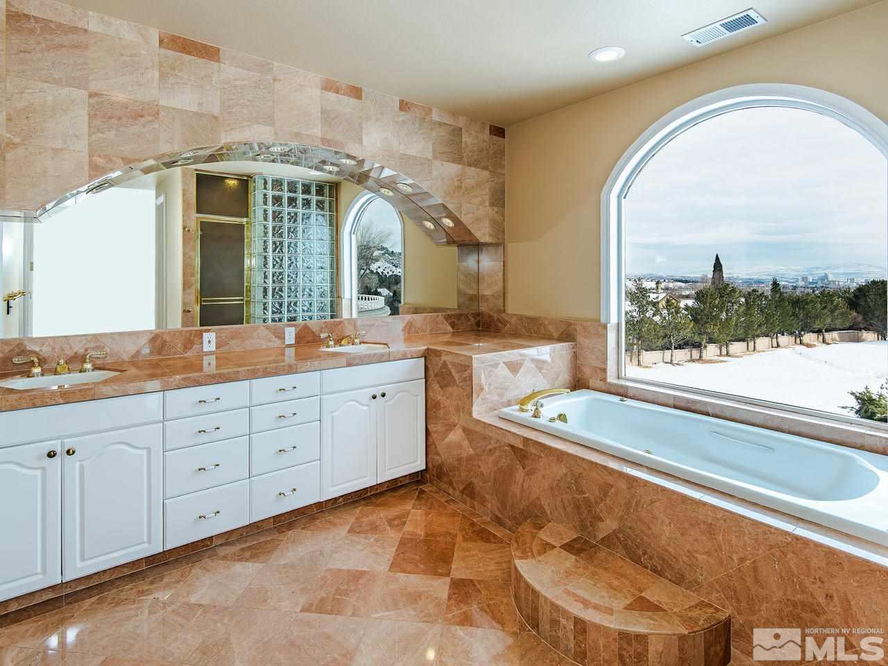4195 Basque Lane Reno, NV 89519 - Photo 14 of 24 a spacious bathroom with a mirror a bathtub and a sink