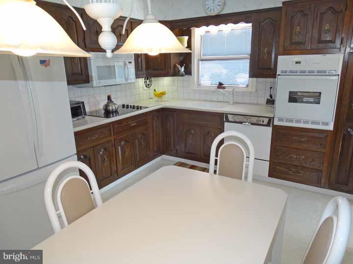 1001 Susan Road Philadelphia, PA 19115 - Photo 8 of 25 a kitchen with stainless steel appliances a sink a stove a microwave a sink and cabinets