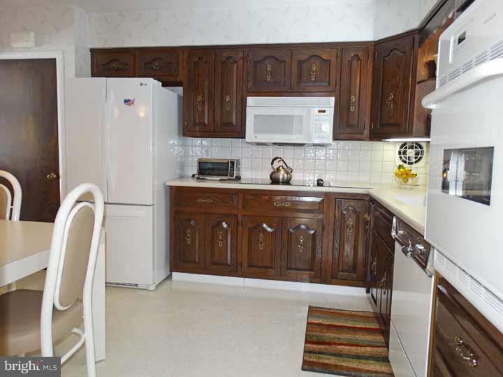 1001 Susan Road Philadelphia, PA 19115 - Photo 10 of 25 a kitchen with stainless steel appliances granite countertop a refrigerator sink and wooden cabinets