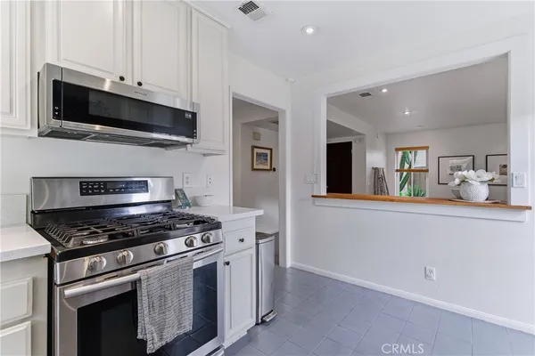 a kitchen with stainless steel appliances white cabinets and a stove top oven