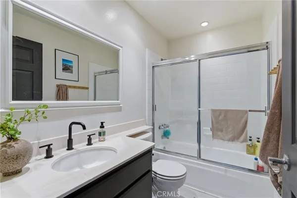 a bathroom with a granite countertop sink toilet and shower