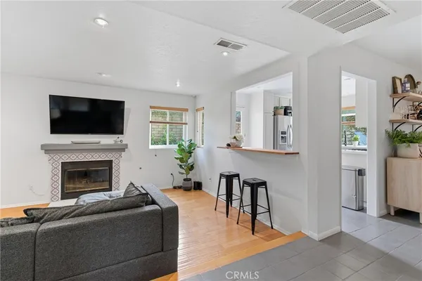 a living room with furniture a flat screen tv and a fireplace