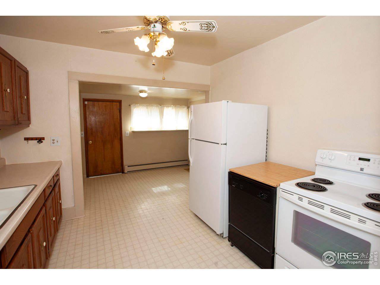 323 Cleveland Street Sterling, CO 80751 - Photo 11 of 28 a kitchen with refrigerator and cabinets