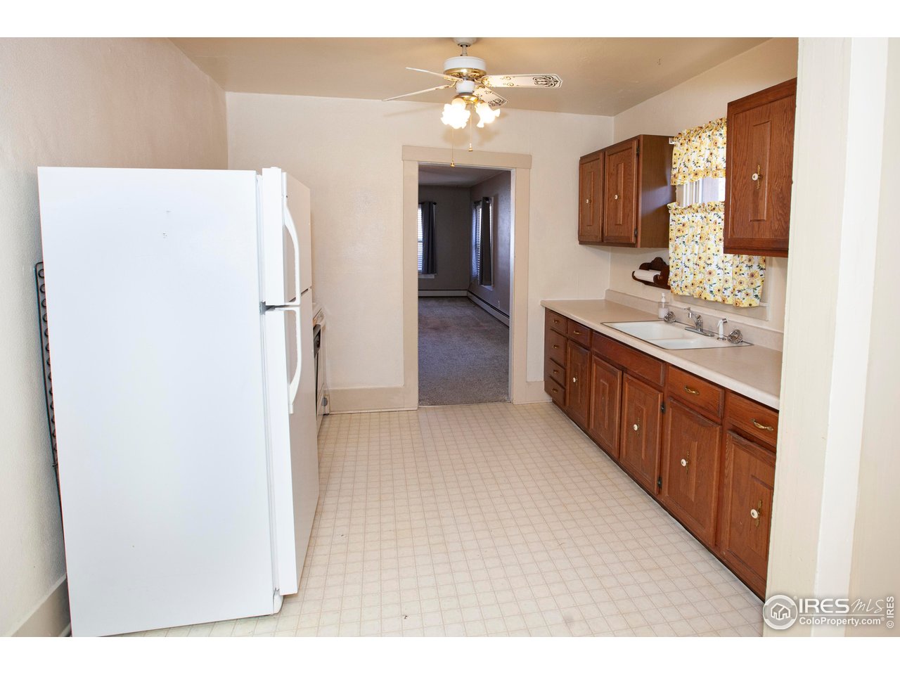 323 Cleveland Street Sterling, CO 80751 - Photo 13 of 28 a kitchen with a refrigerator and a sink