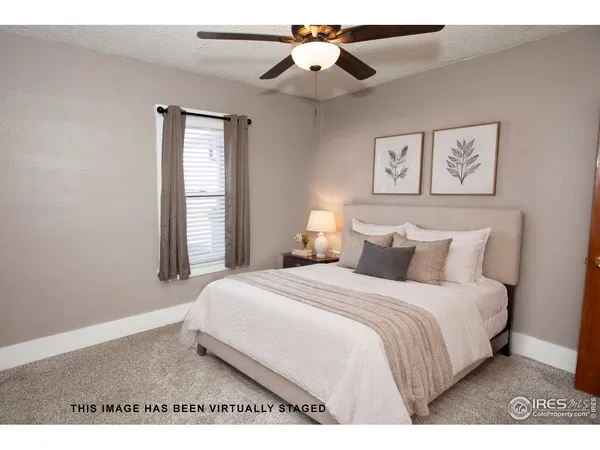 a view of an empty room with window and chandelier fan