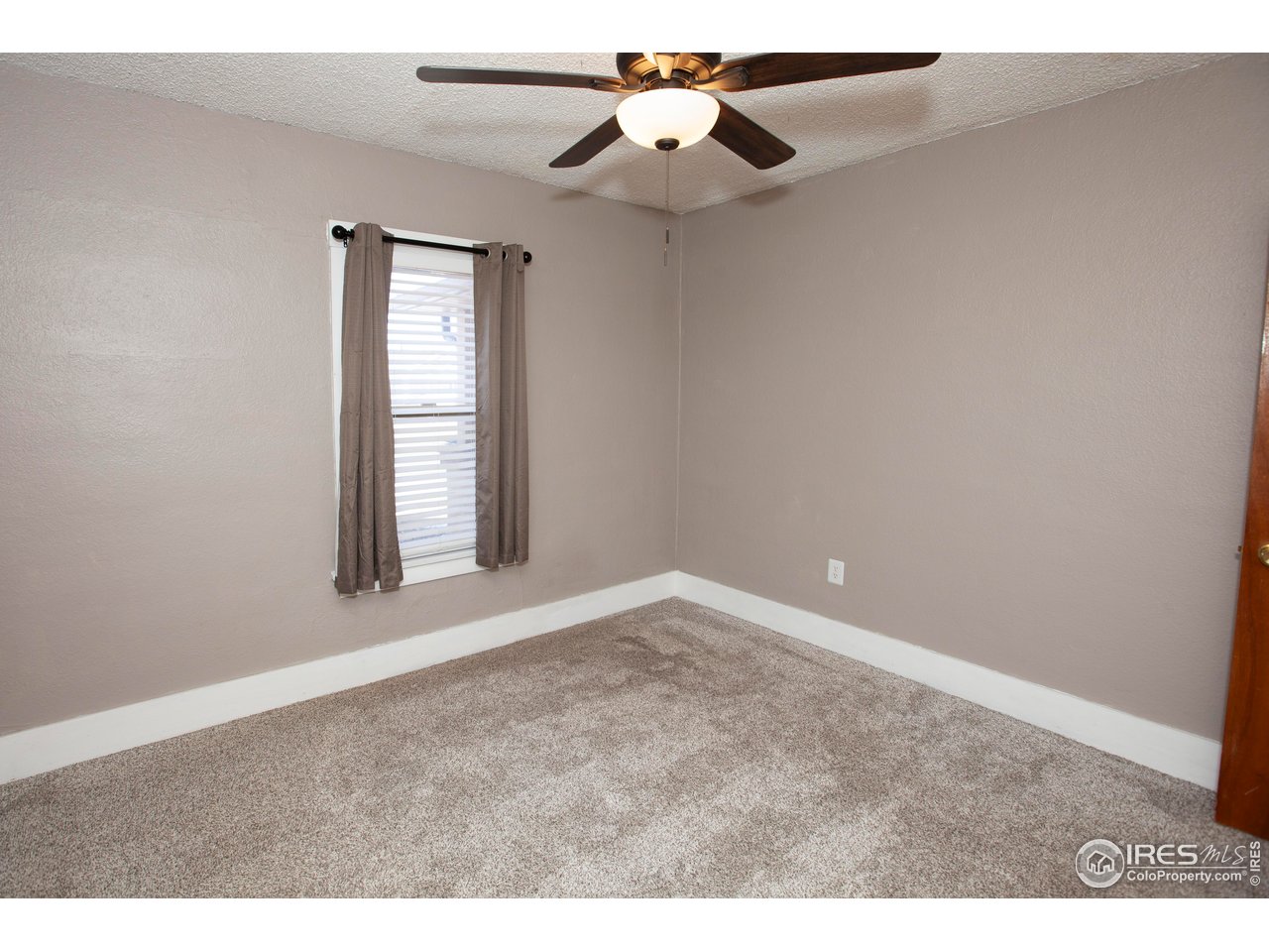 323 Cleveland Street Sterling, CO 80751 - Photo 18 of 28 a view of an empty room with window and chandelier fan