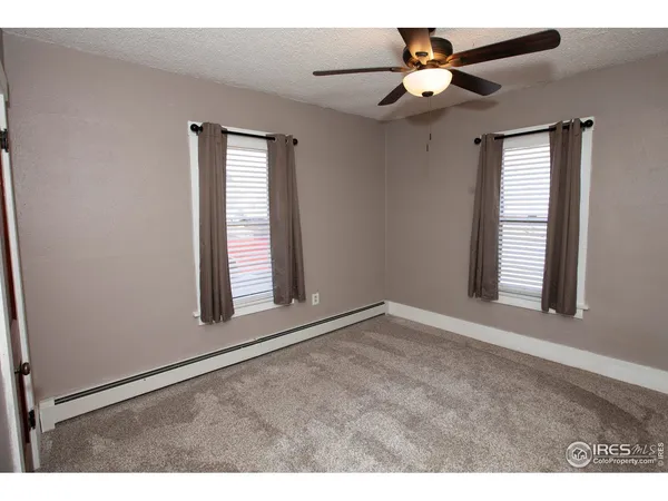 a spacious bedroom with a bed a couch and a chandelier