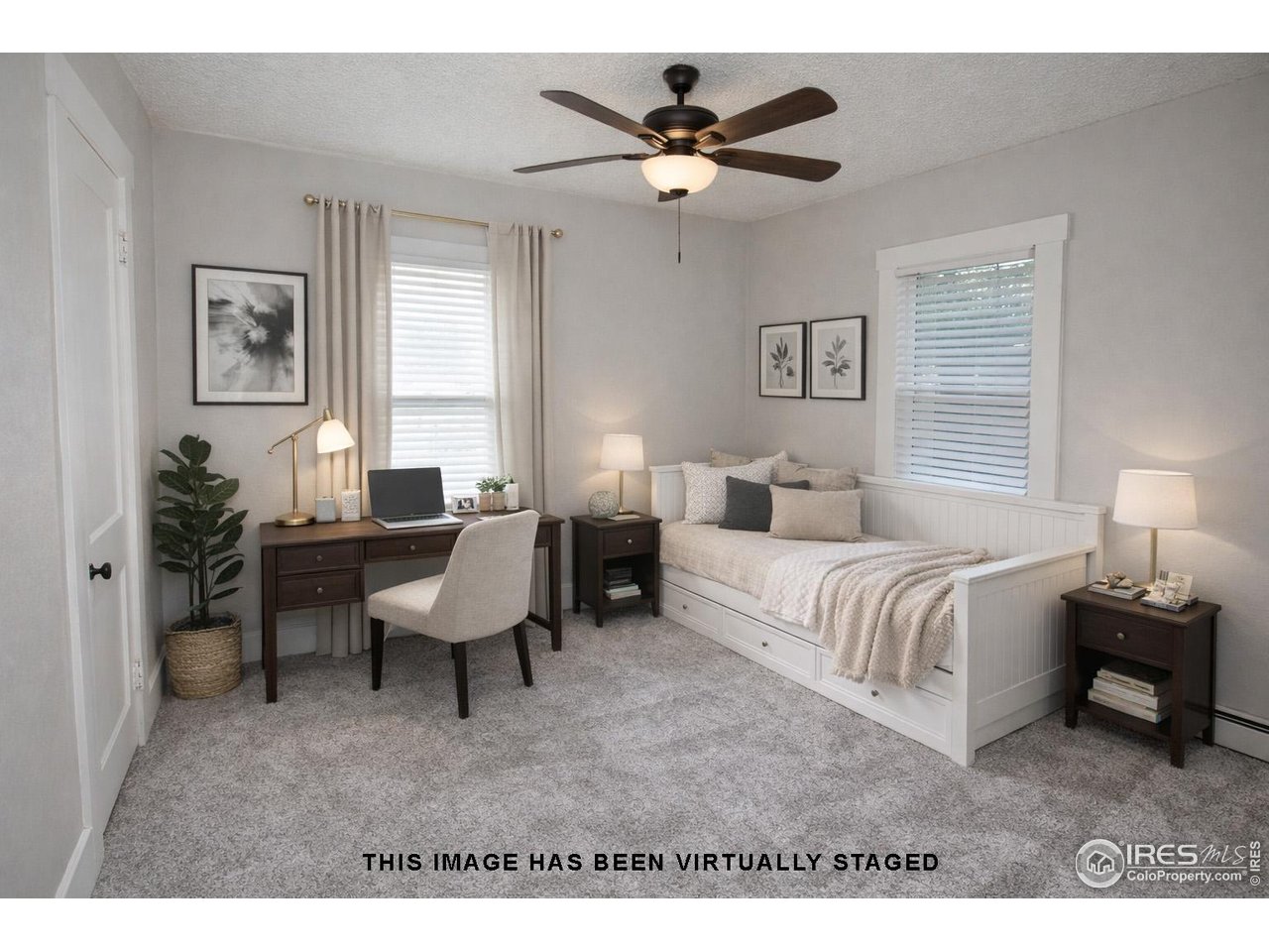 323 Cleveland Street Sterling, CO 80751 - Photo 21 of 28 a spacious bedroom with a bed a couch and a chandelier