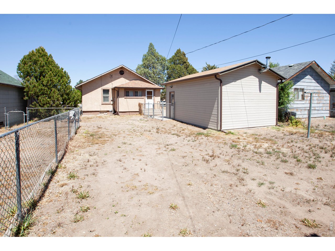 323 Cleveland Street Sterling, CO 80751 - Photo 28 of 28 a view of wooden house with a yard and large trees