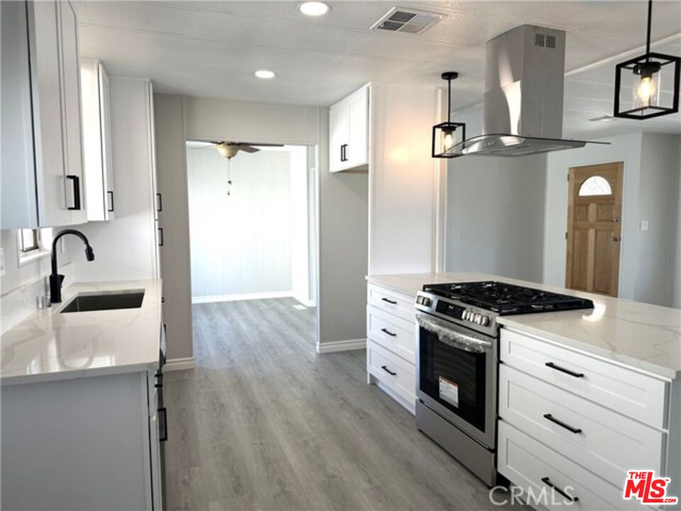 9391 California Avenue, Unit 89 Riverside, CA 92503 - Photo 6 of 16 a kitchen with granite countertop a sink stainless steel appliances and cabinets