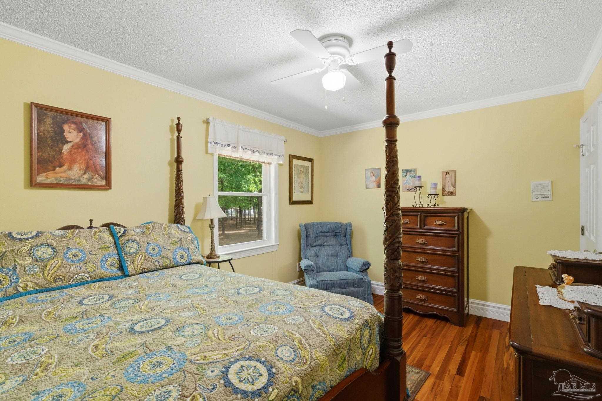6930 Summit Way Milton, FL 32570 - Photo 36 of 71 a bedroom with a bed and a chandelier