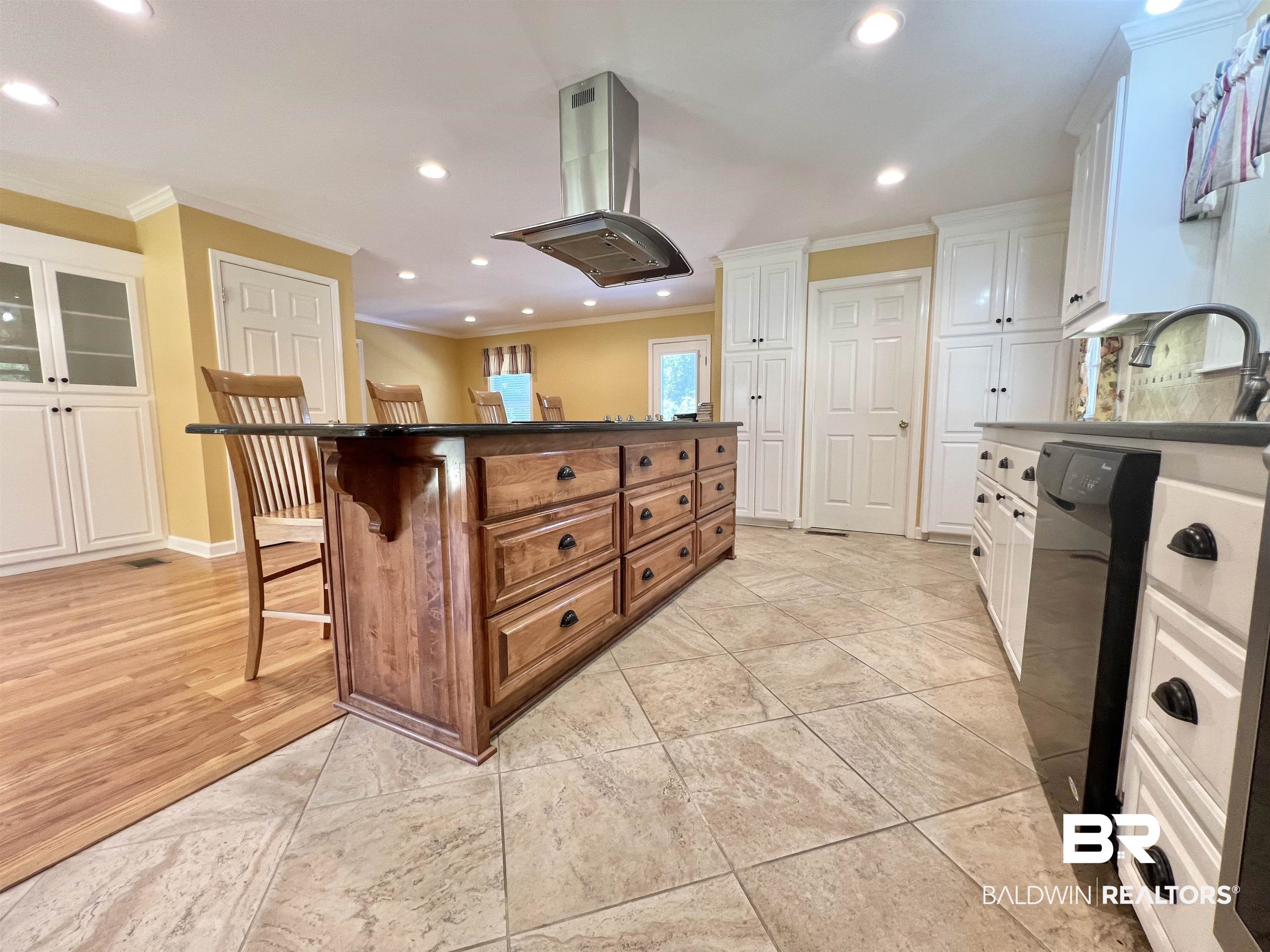 2691 Appleton Road Brewton, AL 36426 - Photo 14 of 60 Kitchen with a breakfast bar, island range hood, recessed lighting, ornamental molding, and brown cabinets