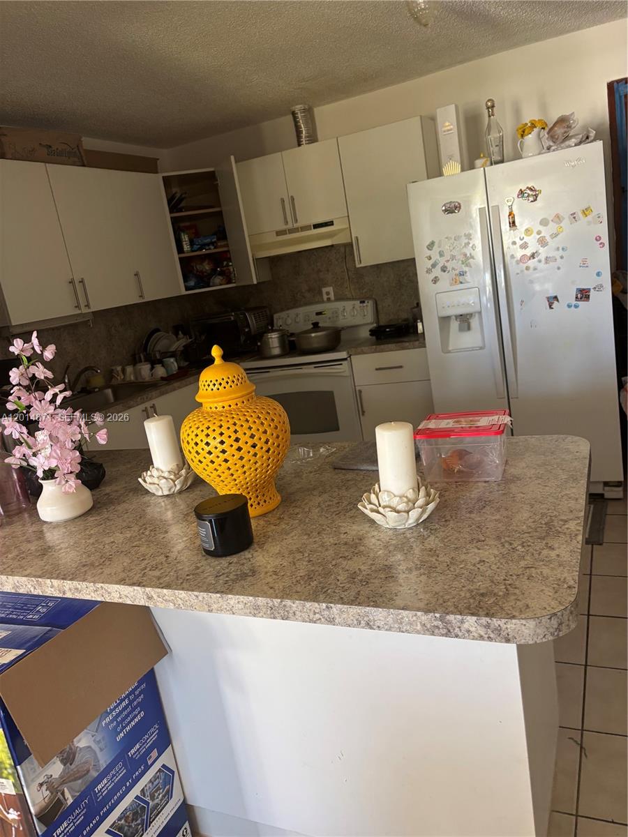 116 Allen Road West Park, FL 33023 - Photo 10 of 15 a kitchen with stainless steel appliances granite countertop a sink white cabinets and a stove
