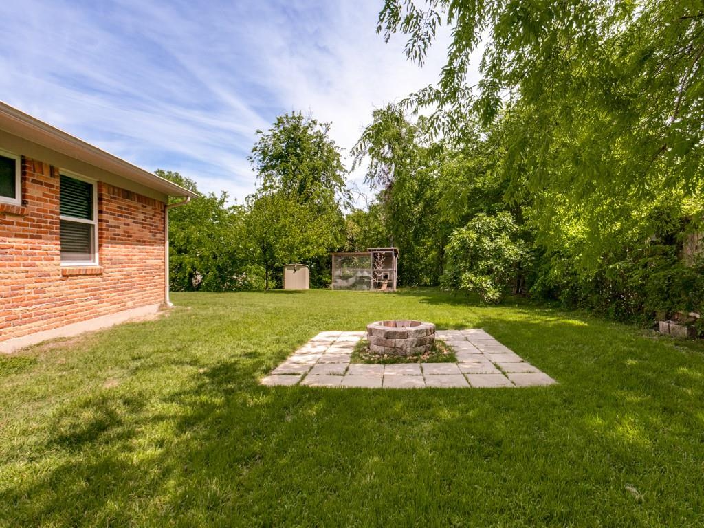 1106 Ridgeway Circle Richardson, TX 75080 - Photo 4 of 25 View of green lawn featuring an outdoor fire pit, a patio, and an outbuilding