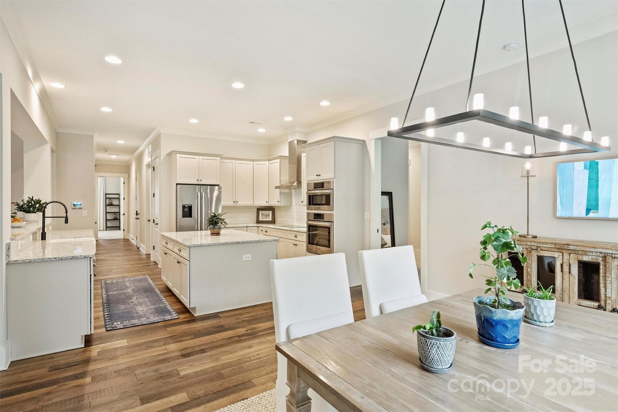 12912 Bailey Road Cornelius, NC 28031 - Photo 9 of 27 a kitchen with stainless steel appliances kitchen island granite countertop a refrigerator a stove and white cabinets with wooden floor