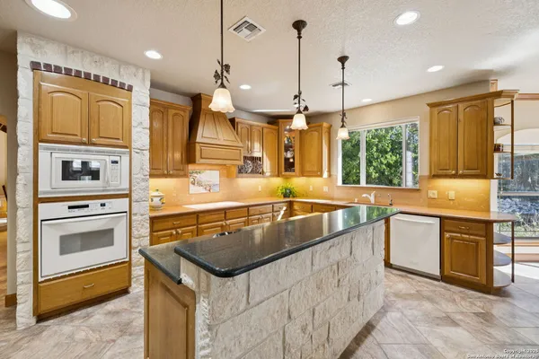 a kitchen with stainless steel appliances granite countertop a sink a stove and a refrigerator