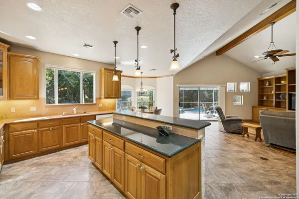 a large kitchen with kitchen island a sink dining table and chairs