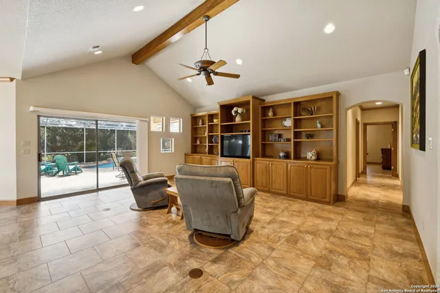 a living room with furniture windows and a flat screen tv