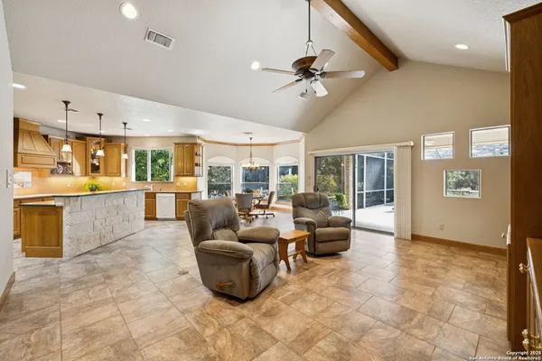 a living room with couches and kitchen view