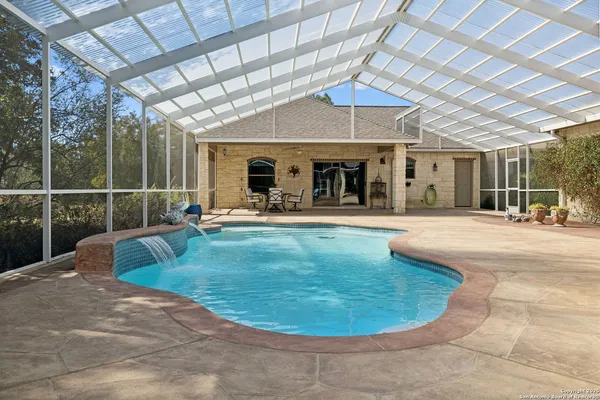 a view of a swimming pool with a patio and a fountain
