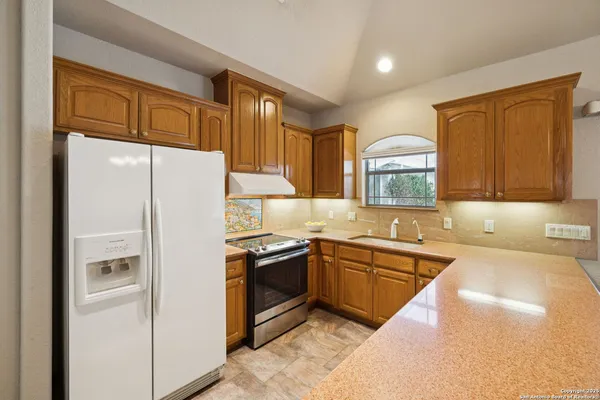 a kitchen with granite countertop a sink stainless steel appliances and cabinets