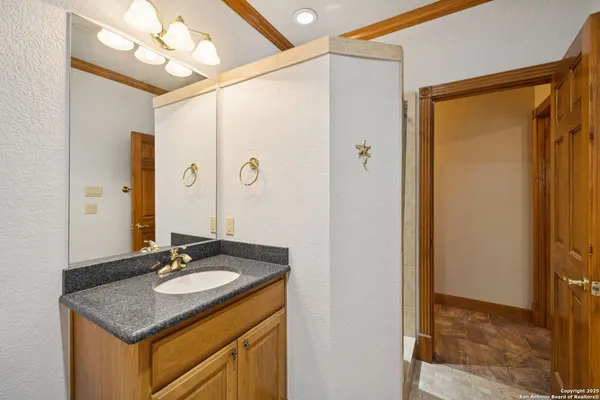 a bathroom with a granite countertop sink and a mirror
