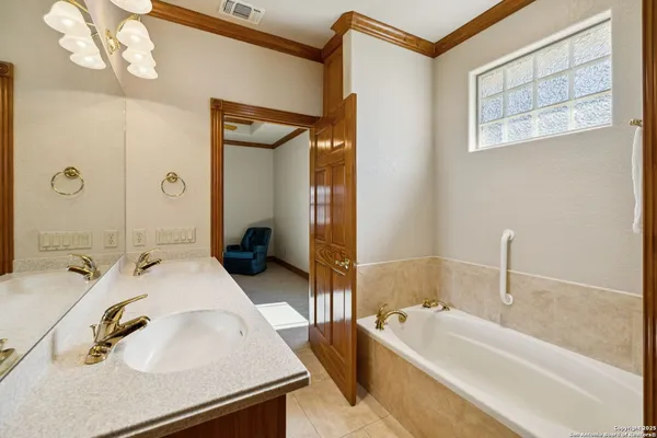 a en suite bathroom with a granite countertop tub and a sink