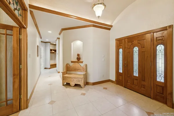a view of a hallway with entryway bedroom and bedroom with chandelier fan